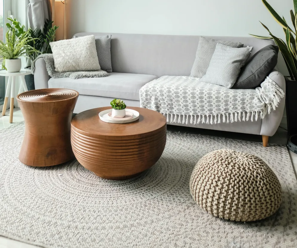 Living room with a gray sofa and round wooden coffee tables