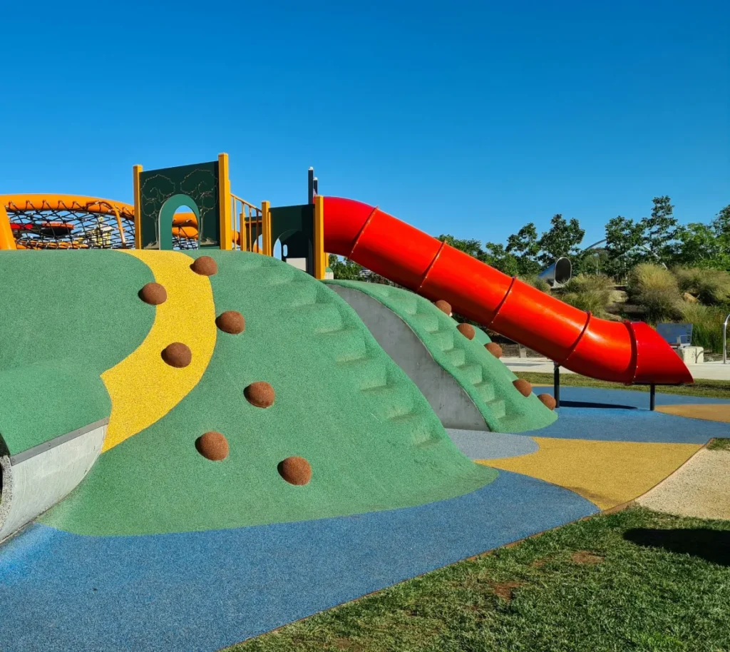 Playground with a red slide and colorful climbing area