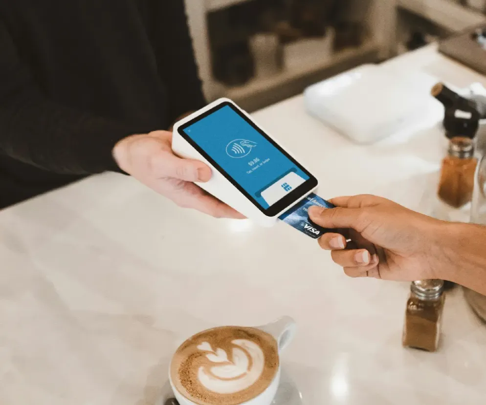 Customer inserting a bank card into a handheld payment terminal