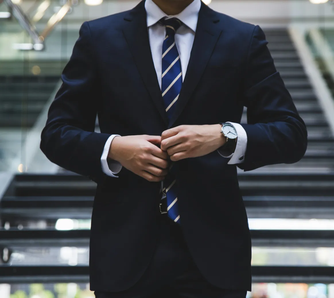 Business professional adjusting a navy suit jacket