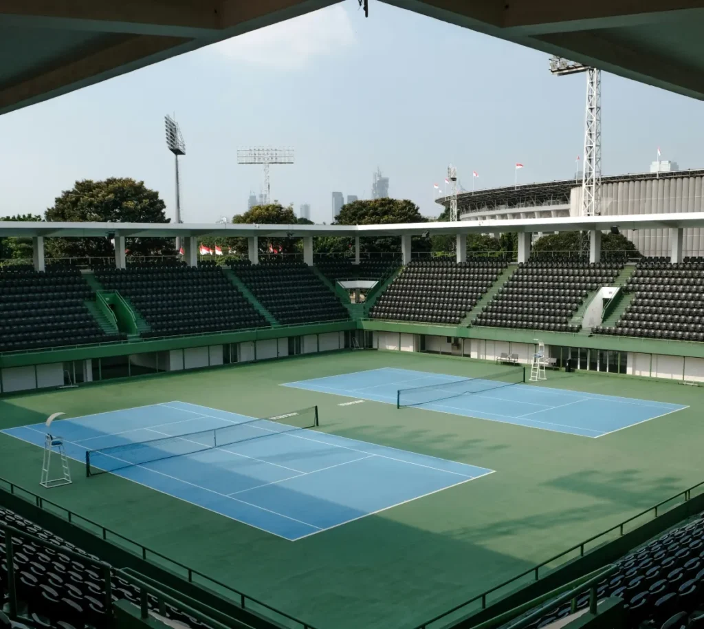 Outdoor tennis courts surrounded by stadium seating