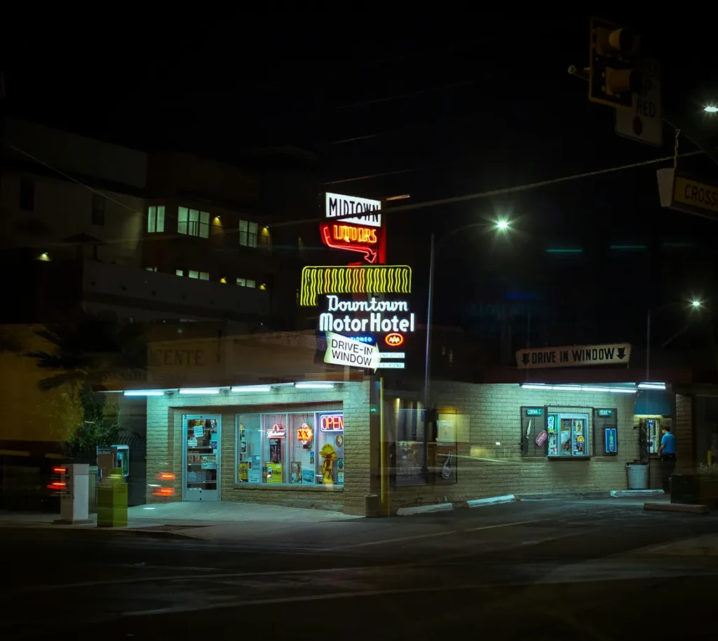 Liquor store with illuminated signs and a drive through window at night
